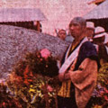 Postcard: A buddhist monk stands in front of a large ash mound at the site of the Honjo Clothing Depot