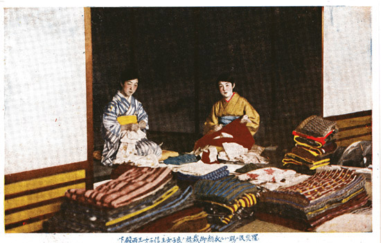 Postcard of volunteers collecting blankets and other relief materials for disaster sufferers